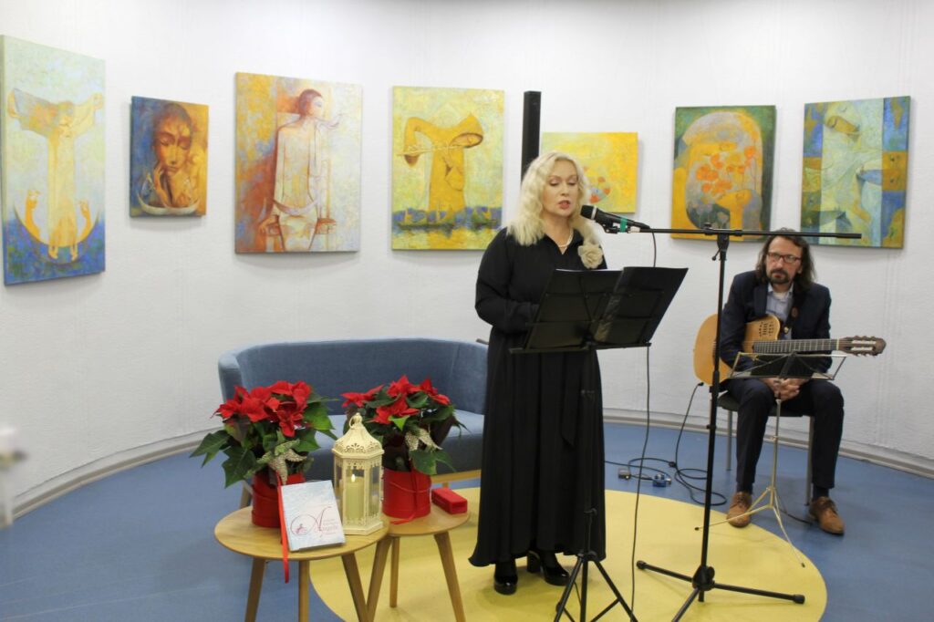 Aktorė E. Koriznaitė skaito poeziją, sėdi gitaristas R. Januševičus su gitara