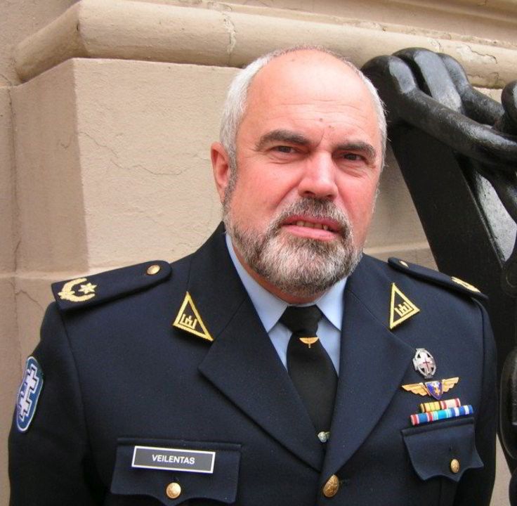 Kunigas, pedagogas, žurnalistas, lakūnas, Lietuvos karinių oro pajėgų kapelionas Virgilijus Veilentas su karininko uniforma. Nuotrauka spalvota.