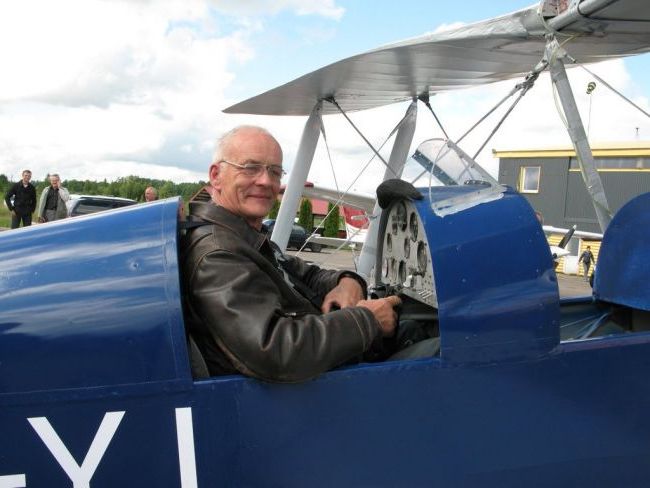 Lakūnas, instruktorius, aviakonstruktorius Vincas Mikeliūnas sėdintis savo sukonstruotame lėktuve. Nuottauka spalvota.
