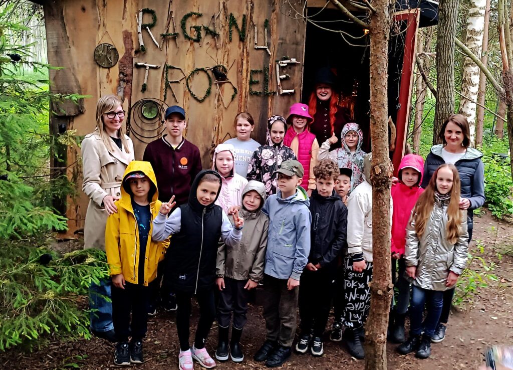 Vaikų būrys miške prie raganos trobelės