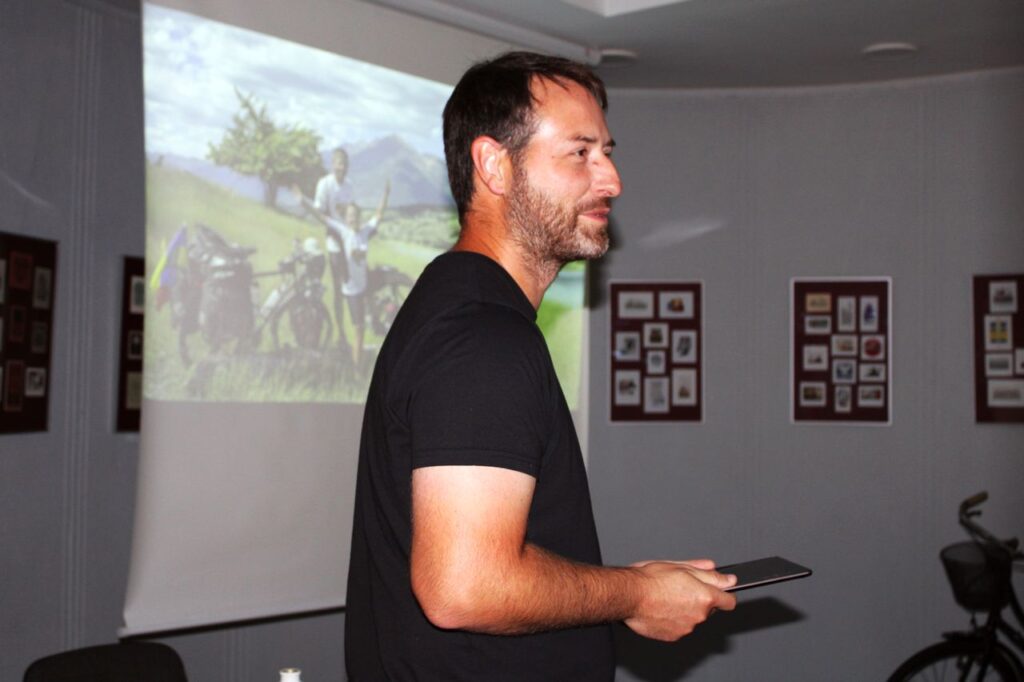 Vyras prie ekrano demonstruoja skaidres iš kelionių