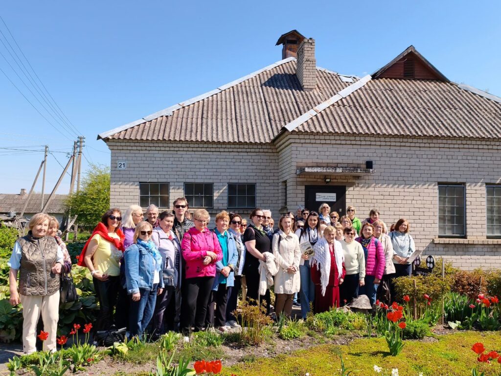 Žmonių grupė Raguvoje šalia privataus muziejaus (baltas mūrinis namas)