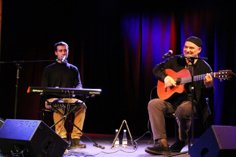 Du vyra scenoje, vienas su klavišiniais, kitas su gitara